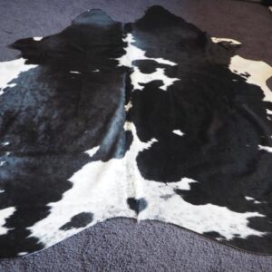 A Beautiful Speckled White Breaks the High Gloss Black of this Gorgeous Cowhide Rug